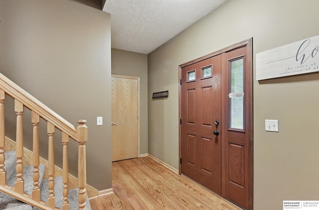 2103 John St, Papillion, NE 68133 - entrance foyer with wood finished floors, stairs, baseboards, and a textured ceiling