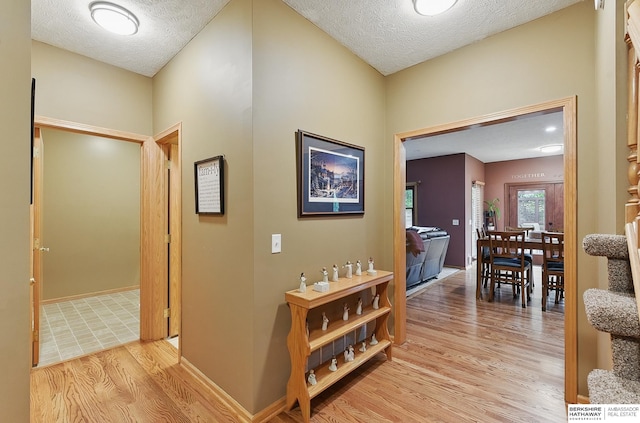 2103 John St, Papillion, NE 68133 - corridor with light wood-type flooring, a textured ceiling, and baseboards