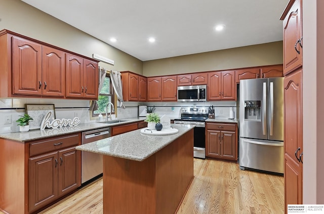 2103 John St, Papillion, NE 68133 - kitchen with appliances with stainless steel finishes, a sink, light wood-style flooring, tasteful backsplash, and light stone counters