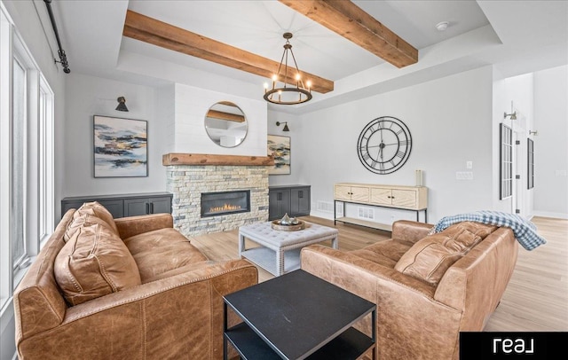 18880 Patrick Cir, Elkhorn, NE 68022 - living area with wood finished floors, a chandelier, beam ceiling, baseboards, and a stone fireplace