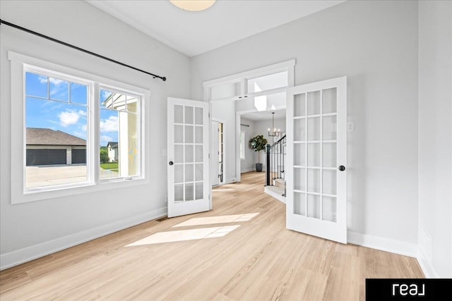 18880 Patrick Cir, Elkhorn, NE 68022 - spare room with wood finished floors, a chandelier, baseboards, and french doors