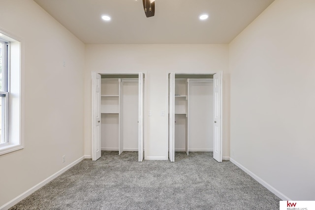 unfurnished bedroom featuring two closets, carpet, recessed lighting, and baseboards