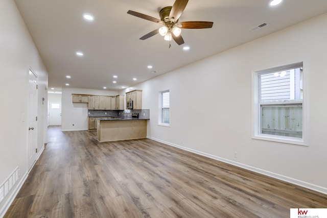 unfurnished living room with ceiling fan, recessed lighting, baseboards, and wood finished floors