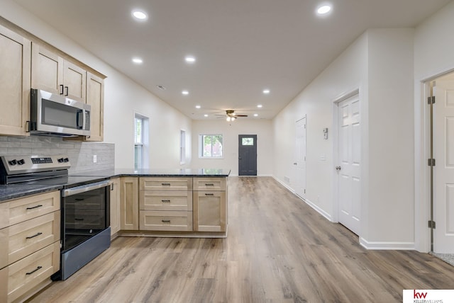 kitchen featuring stainless steel appliances, a peninsula, light wood-style floors, recessed lighting, and light brown cabinetry