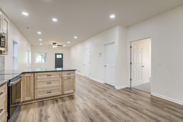 kitchen with light wood finished floors, a peninsula, a ceiling fan, recessed lighting, and baseboards