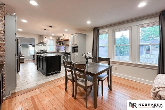 dining space featuring healthy amount of natural light, light wood-type flooring, recessed lighting, and baseboards