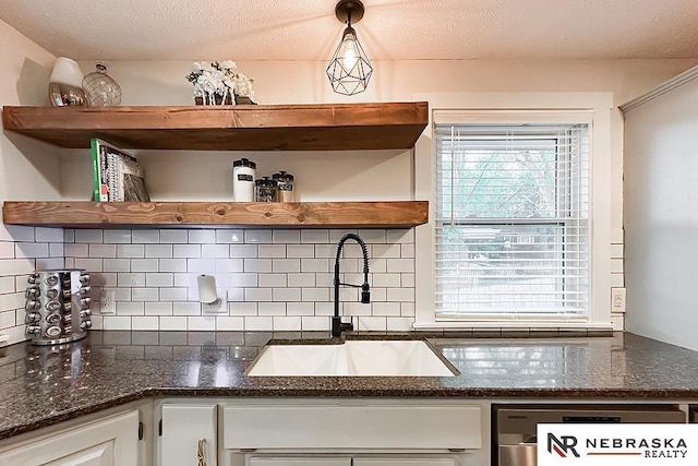 kitchen with open shelves, a sink, tasteful backsplash, white cabinets, and dark stone countertops