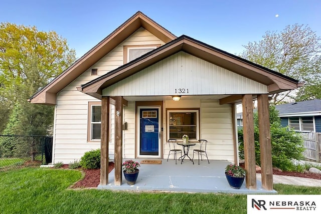 view of front of home featuring a porch and fence
