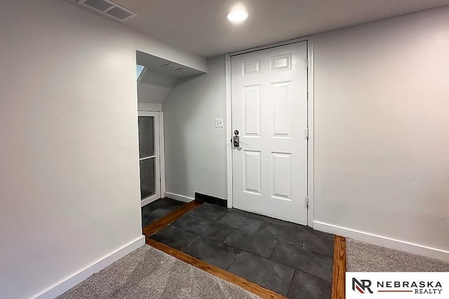 foyer entrance with baseboards and recessed lighting