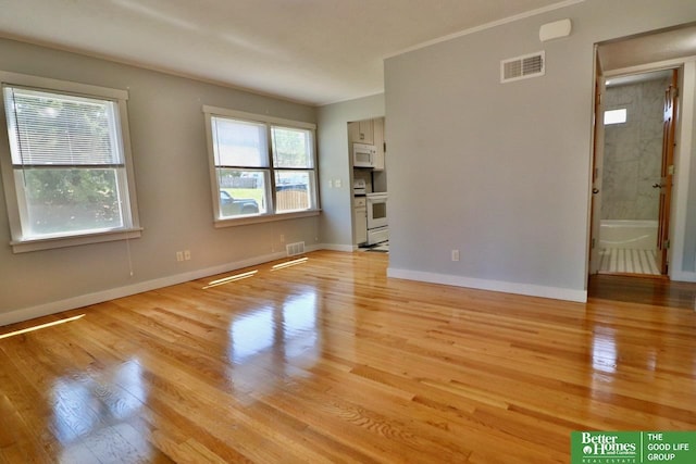 spare room featuring light wood finished floors and baseboards