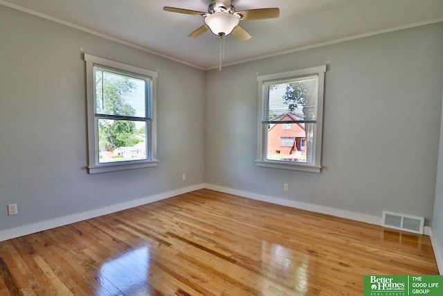 unfurnished room with plenty of natural light, crown molding, hardwood / wood-style flooring, ceiling fan, and baseboards