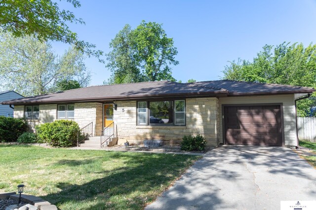 5 Fairview Dr, York, NE 68467 - ranch-style home featuring stone siding, an attached garage, asphalt driveway, a front yard, and roof with shingles