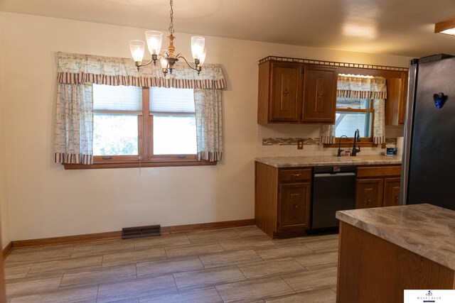 5 Fairview Dr, York, NE 68467 - kitchen with dishwashing machine, a chandelier, light countertops, baseboards, and decorative light fixtures