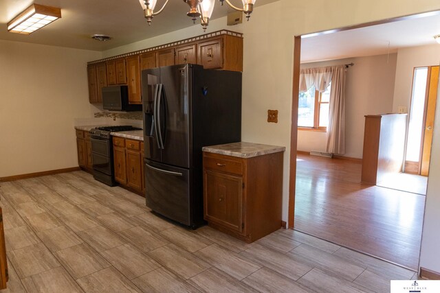 5 Fairview Dr, York, NE 68467 - kitchen with appliances with stainless steel finishes, light countertops, a chandelier, brown cabinetry, and baseboards