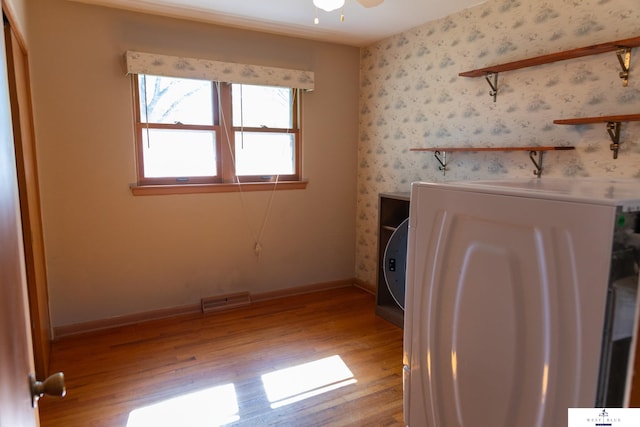 5 Fairview Dr, York, NE 68467 - unfurnished living room with washer / dryer, wood finished floors, baseboards, and wallpapered walls