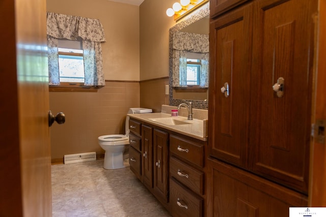 5 Fairview Dr, York, NE 68467 - bathroom with healthy amount of natural light, tile walls, toilet, a wainscoted wall, and vanity