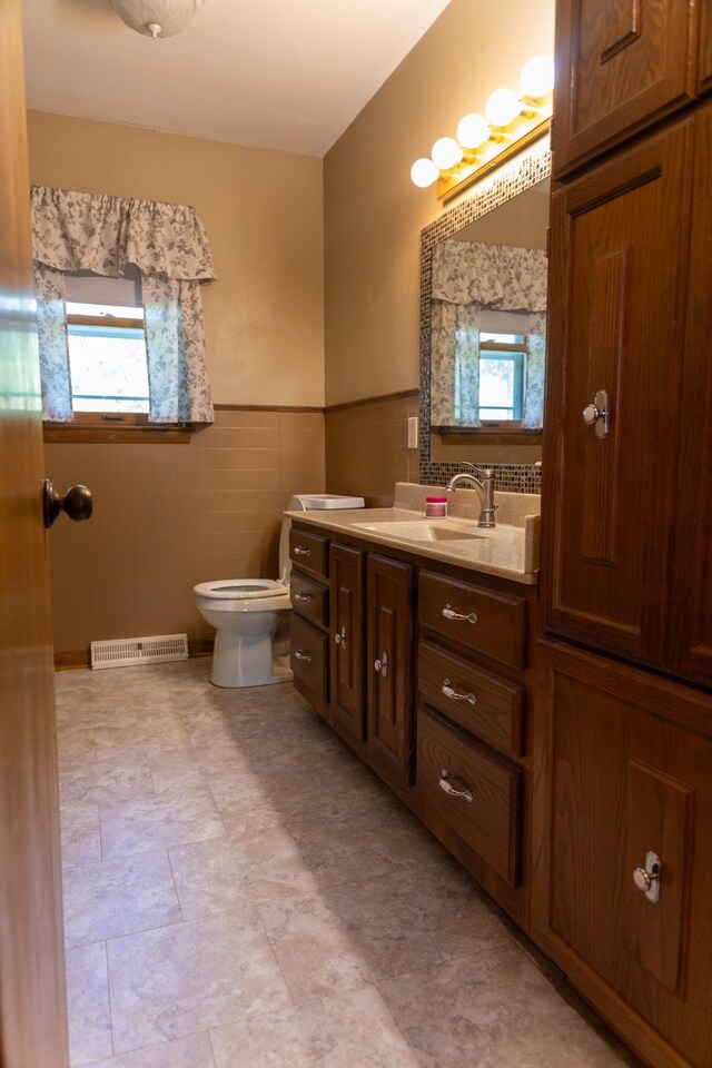 5 Fairview Dr, York, NE 68467 - bathroom with tile walls, plenty of natural light, toilet, a wainscoted wall, and vanity