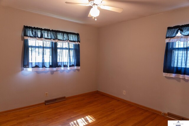5 Fairview Dr, York, NE 68467 - unfurnished room featuring plenty of natural light, wood finished floors, a ceiling fan, and baseboards