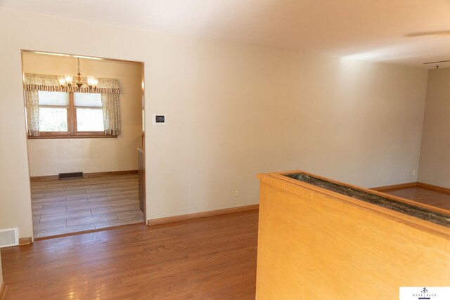 5 Fairview Dr, York, NE 68467 - hallway featuring a chandelier, wood finished floors, and baseboards