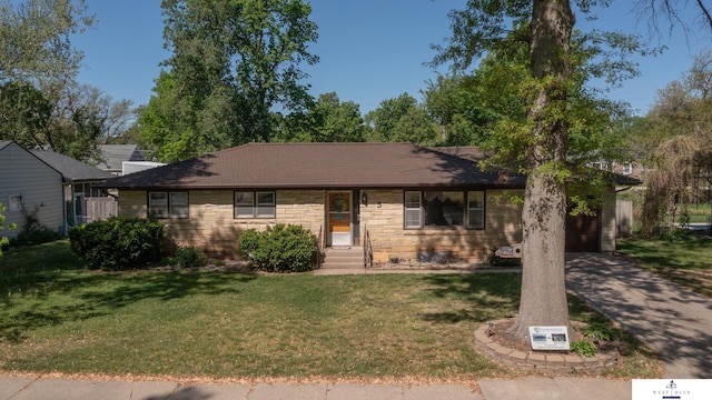 5 Fairview Dr, York, NE 68467 - ranch-style house featuring a front lawn, asphalt driveway, an attached garage, and stone siding
