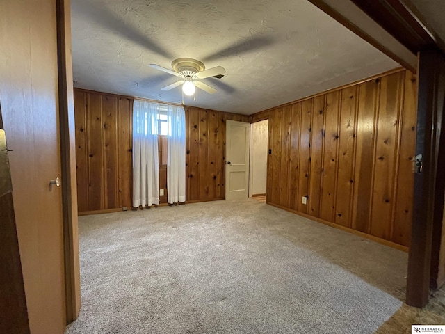 1801 Franklin St, Bellevue, NE 68005 - unfurnished bedroom featuring wood walls, carpet flooring, baseboards, and a textured ceiling