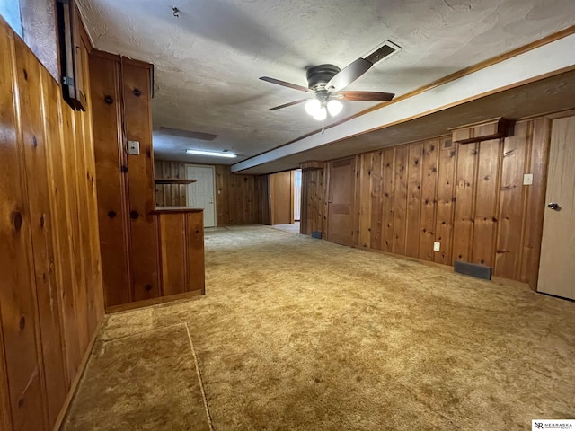 1801 Franklin St, Bellevue, NE 68005 - finished below grade area featuring wood walls, a ceiling fan, carpet flooring, and a textured ceiling