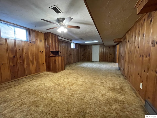 1801 Franklin St, Bellevue, NE 68005 - basement with wood walls, healthy amount of natural light, a textured ceiling, light carpet, and ceiling fan