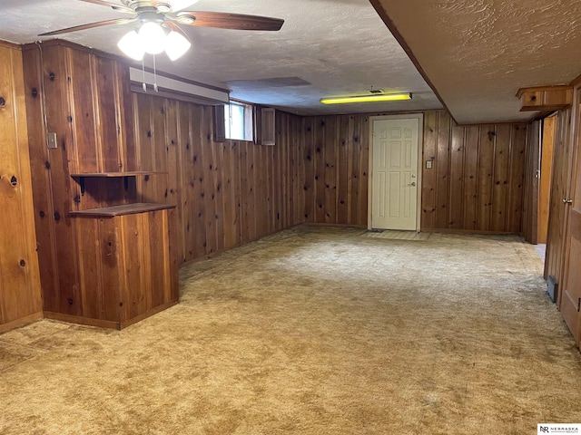 1801 Franklin St, Bellevue, NE 68005 - basement featuring a textured ceiling, wood walls, carpet, and a ceiling fan