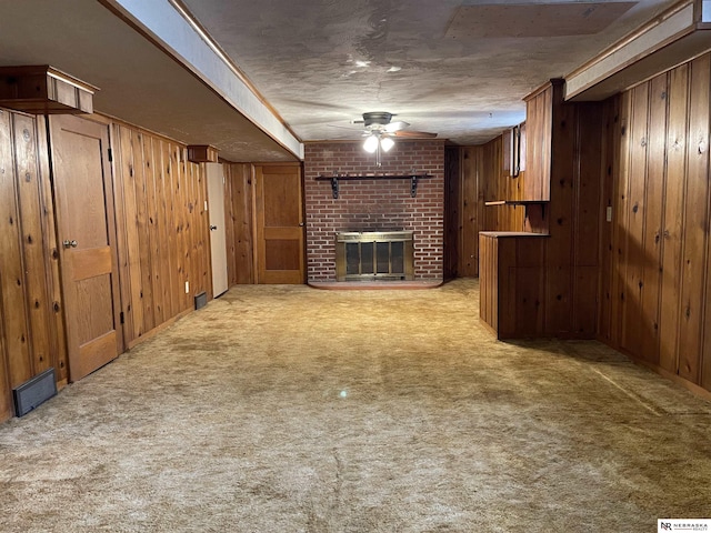 1801 Franklin St, Bellevue, NE 68005 - unfurnished living room with wood walls, ceiling fan, light carpet, and a brick fireplace