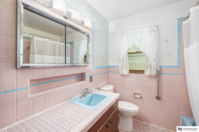 1801 Franklin St, Bellevue, NE 68005 - bathroom featuring vanity, toilet, a wainscoted wall, tile walls, and a shower with curtain