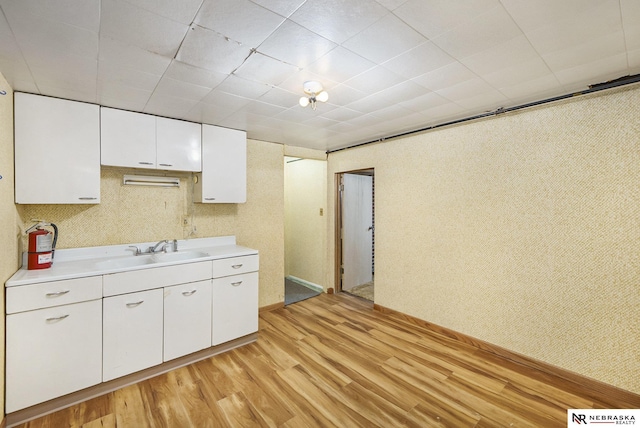 1801 Franklin St, Bellevue, NE 68005 - kitchen with a sink, light wood-style flooring, light countertops, and white cabinetry