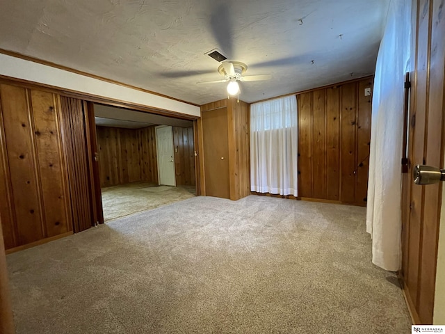 1801 Franklin St, Bellevue, NE 68005 - carpeted empty room with a ceiling fan and wood walls