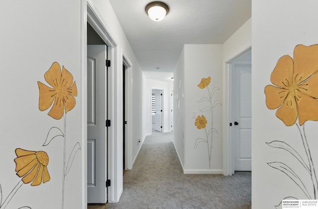 hallway with carpet floors and baseboards