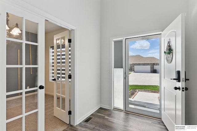 foyer with french doors, wood finished floors, and baseboards