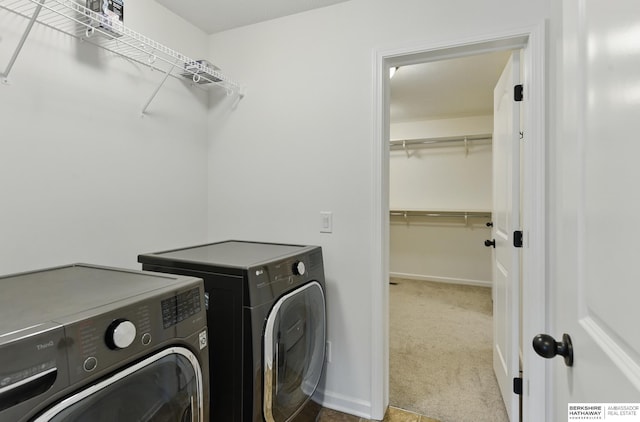 washroom with washing machine and dryer, carpet, and baseboards