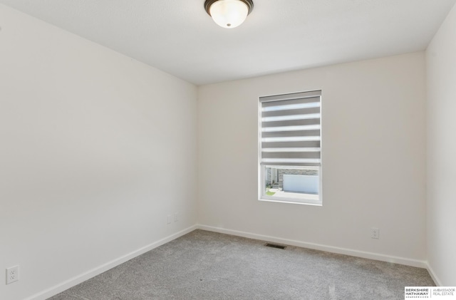 carpeted spare room with baseboards