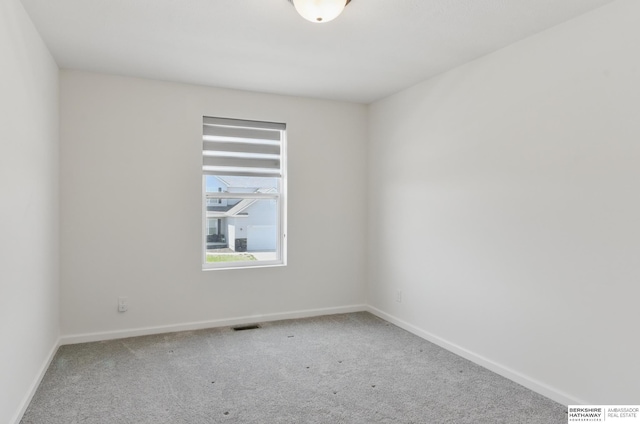 carpeted spare room featuring baseboards