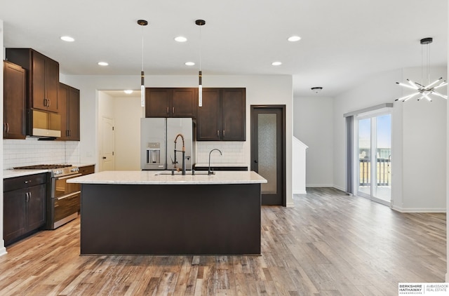 kitchen with appliances with stainless steel finishes, backsplash, light wood-style flooring, dark brown cabinets, and recessed lighting