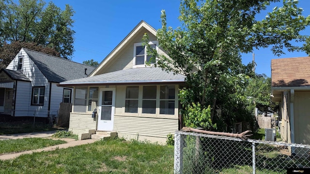 view of front of house featuring entry steps, fence, and roof with shingles