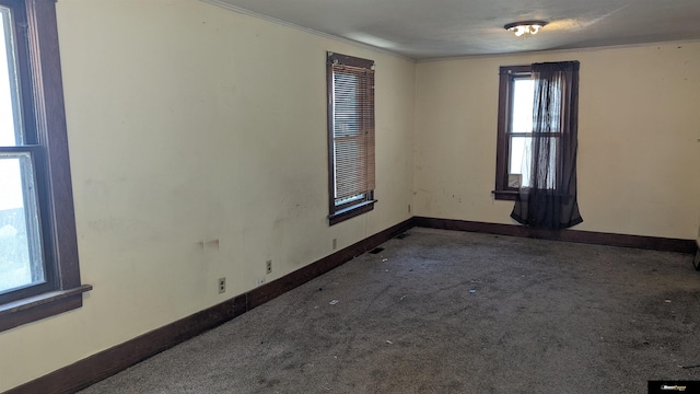 empty room with baseboards, carpet flooring, and crown molding