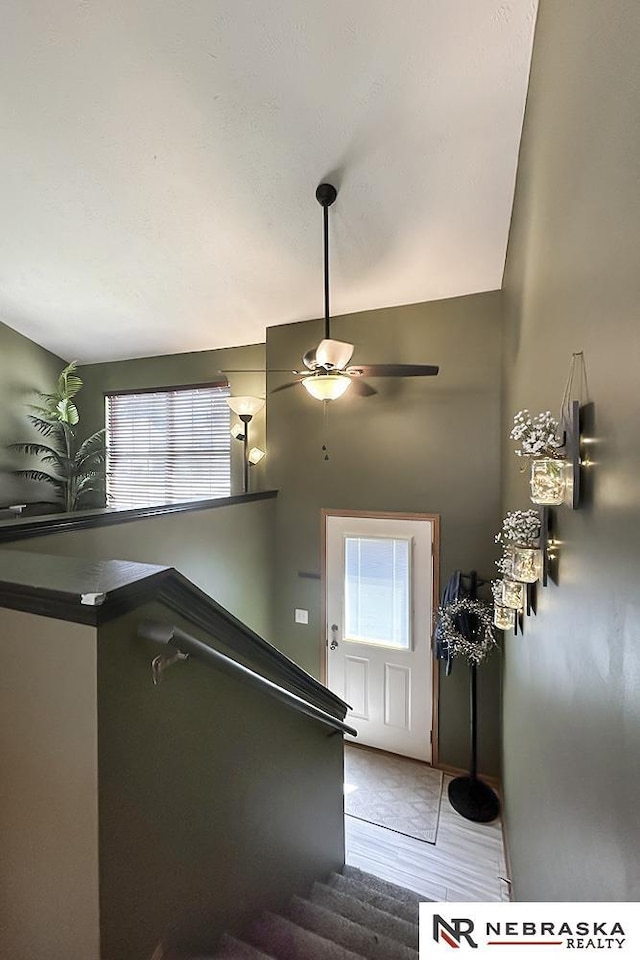 staircase featuring a ceiling fan and tile patterned flooring
