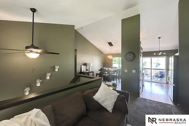living room featuring a ceiling fan, carpet floors, and lofted ceiling