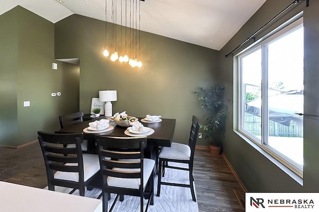 dining room with lofted ceiling, baseboards, and wood finished floors
