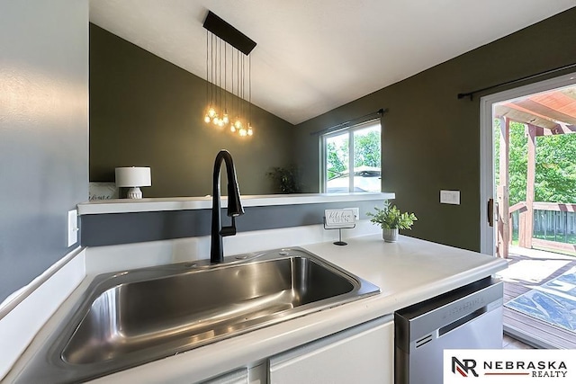 kitchen featuring a sink, lofted ceiling, dishwasher, light countertops, and pendant lighting