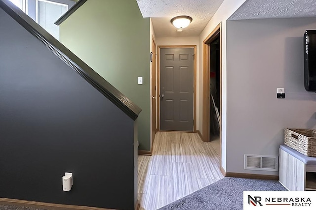entryway with a textured ceiling and baseboards