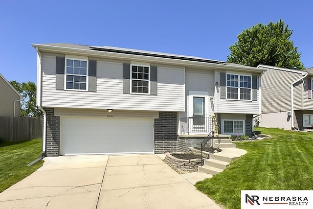 split foyer home featuring brick siding, an attached garage, and driveway