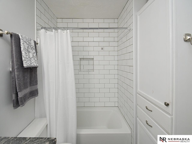 bathroom with shower / bath combo with shower curtain, a textured ceiling, and toilet