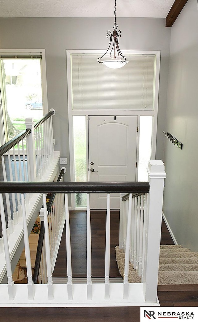foyer with plenty of natural light, stairs, and wood finished floors
