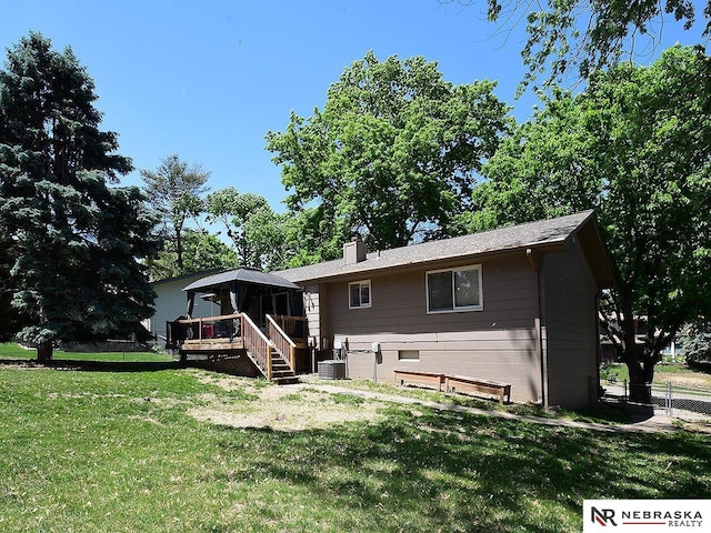 back of house with a deck, a chimney, a sunroom, stairs, and cooling unit