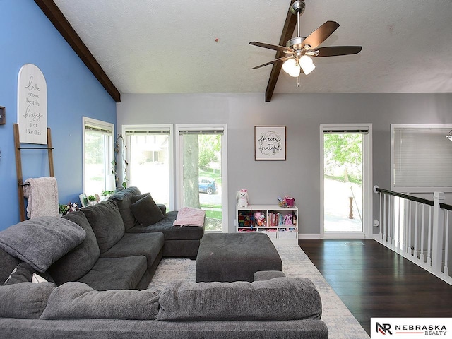 living area featuring dark wood-style flooring, a textured ceiling, a ceiling fan, and plenty of natural light